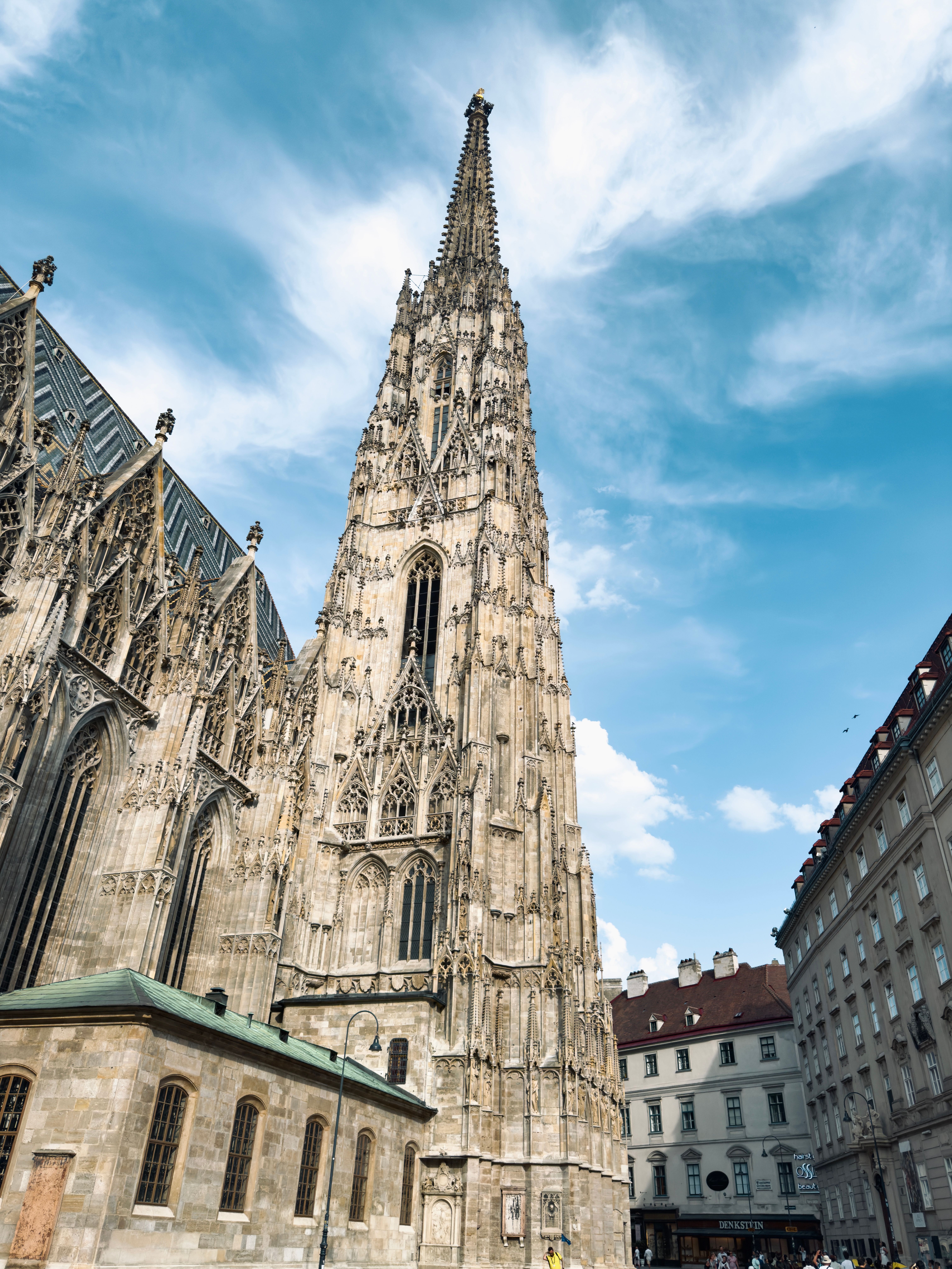 Majestic view of St. Stephen's Cathedral's spire against a blue sky in Vienna, Austria.