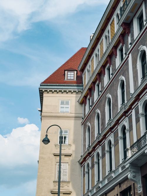 Free Elegant historic buildings with red roofs against a blue sky in Vienna, Austria. Stock Photo