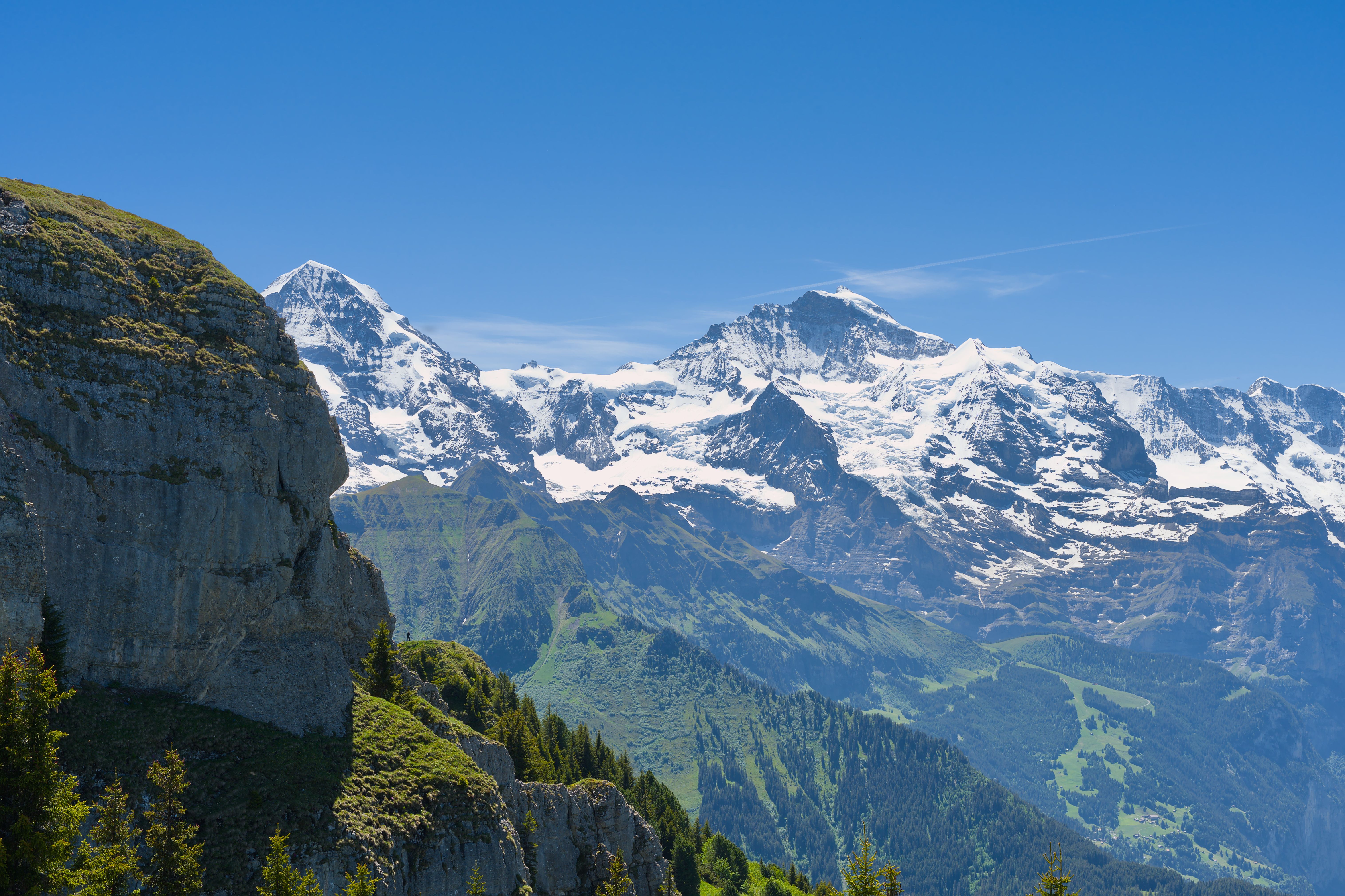 Breathtaking landscape featuring Jungfrau peak and surrounding Swiss Alps under blue skies.