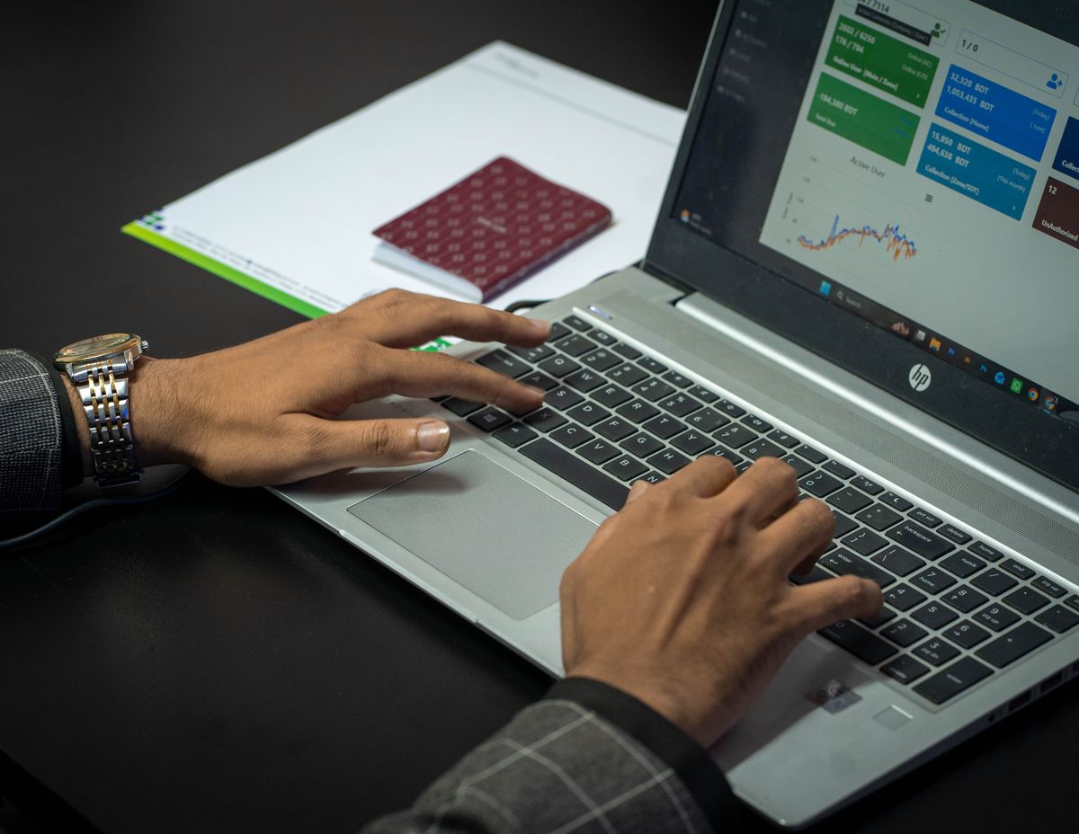 Hands on a laptop keyboard with a business dashboard on screen
