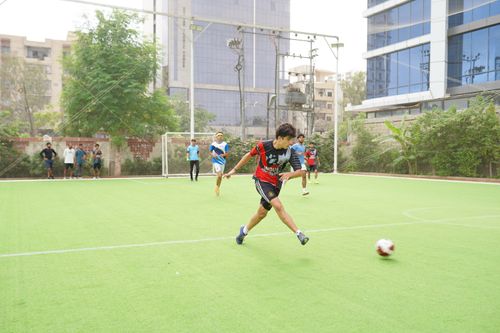 Free A young soccer player in action kicking the ball on an outdoor field surrounded by teammates. Stock Photo