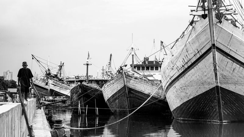 Vintage Pinisi sailing ships moored at Sunda Kelapa harbor in Jakarta