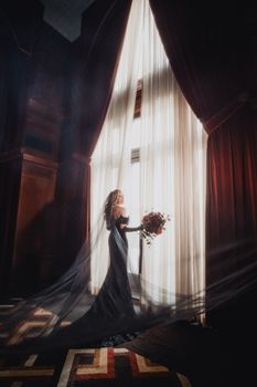Stylish bridal portrait in an elegant indoor setting with dramatic lighting and rich decor.