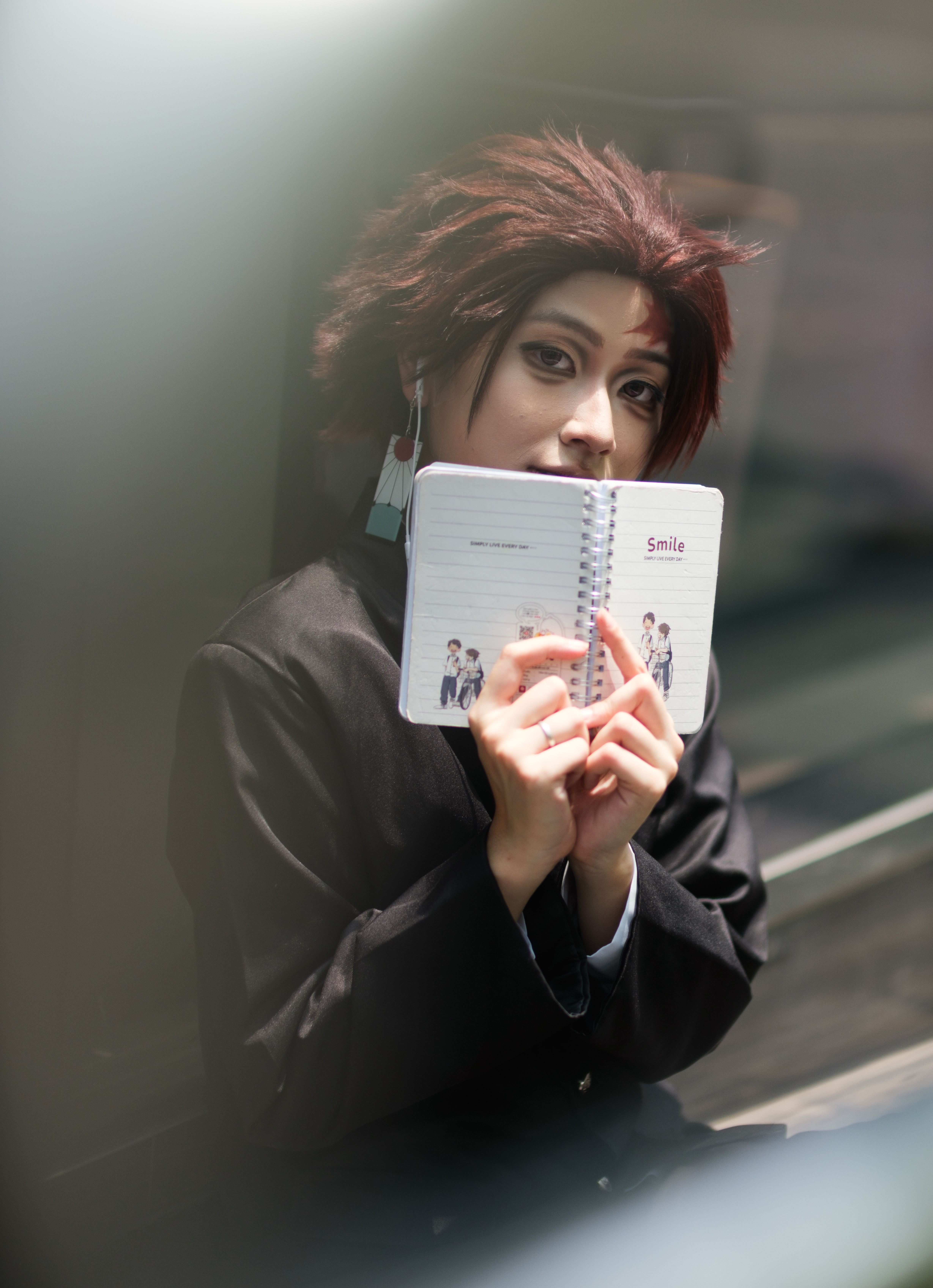 A cosplayer in a costume holds an open notebook, blending creativity and detailed character portrayal.