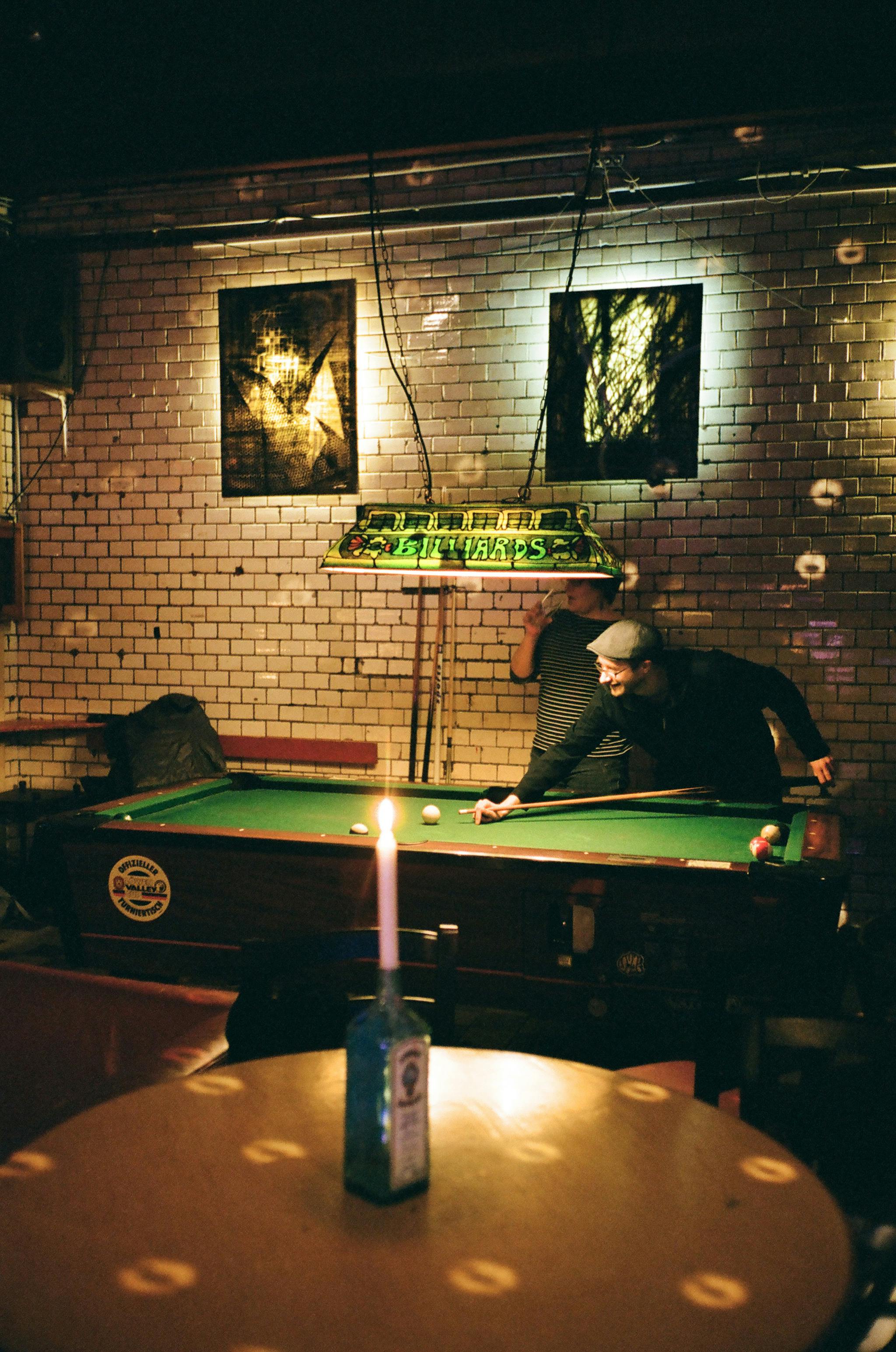 unrecognizable focused man playing billiards in cafe in evening