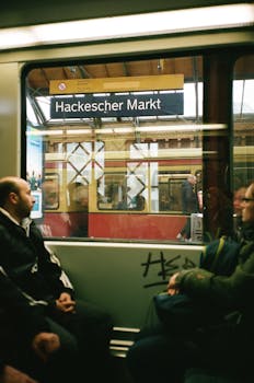 Passengers inside a Berlin subway train at Hackescher Markt station, showcasing urban commute. by Darya Sannikova