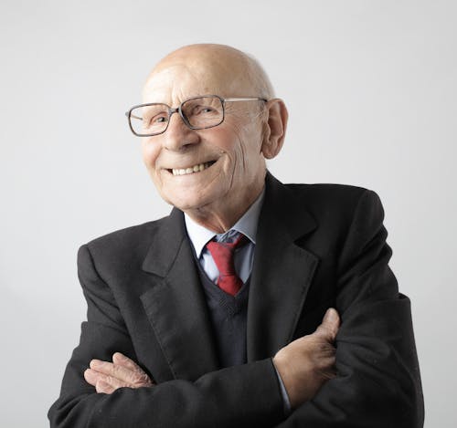 Portrait Photo of Man in Black Suit Jacket Wearing Eyeglasses Smiling