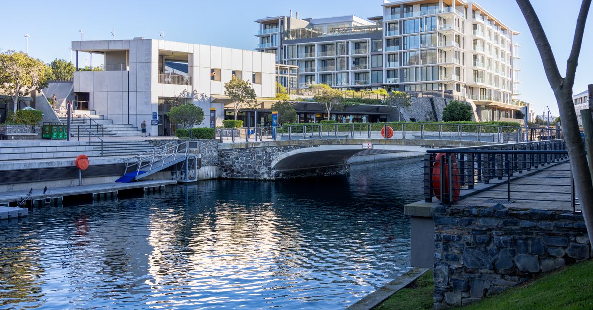 A scenic view of modern architecture along a clean waterfront canal during a clear day.