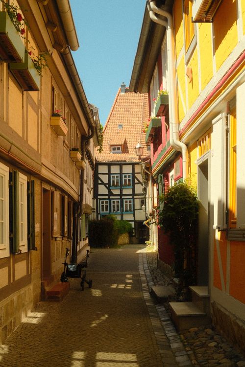 Free Colorful half-timbered houses line a quaint alley in historic Quedlinburg, Germany. Stock Photo