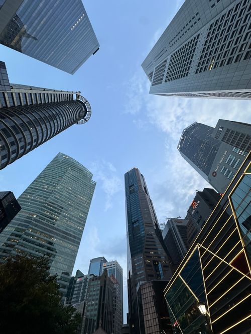 Free Dramatic upward view of modern skyscrapers in Singapore's skyline under a clear blue sky. Stock Photo