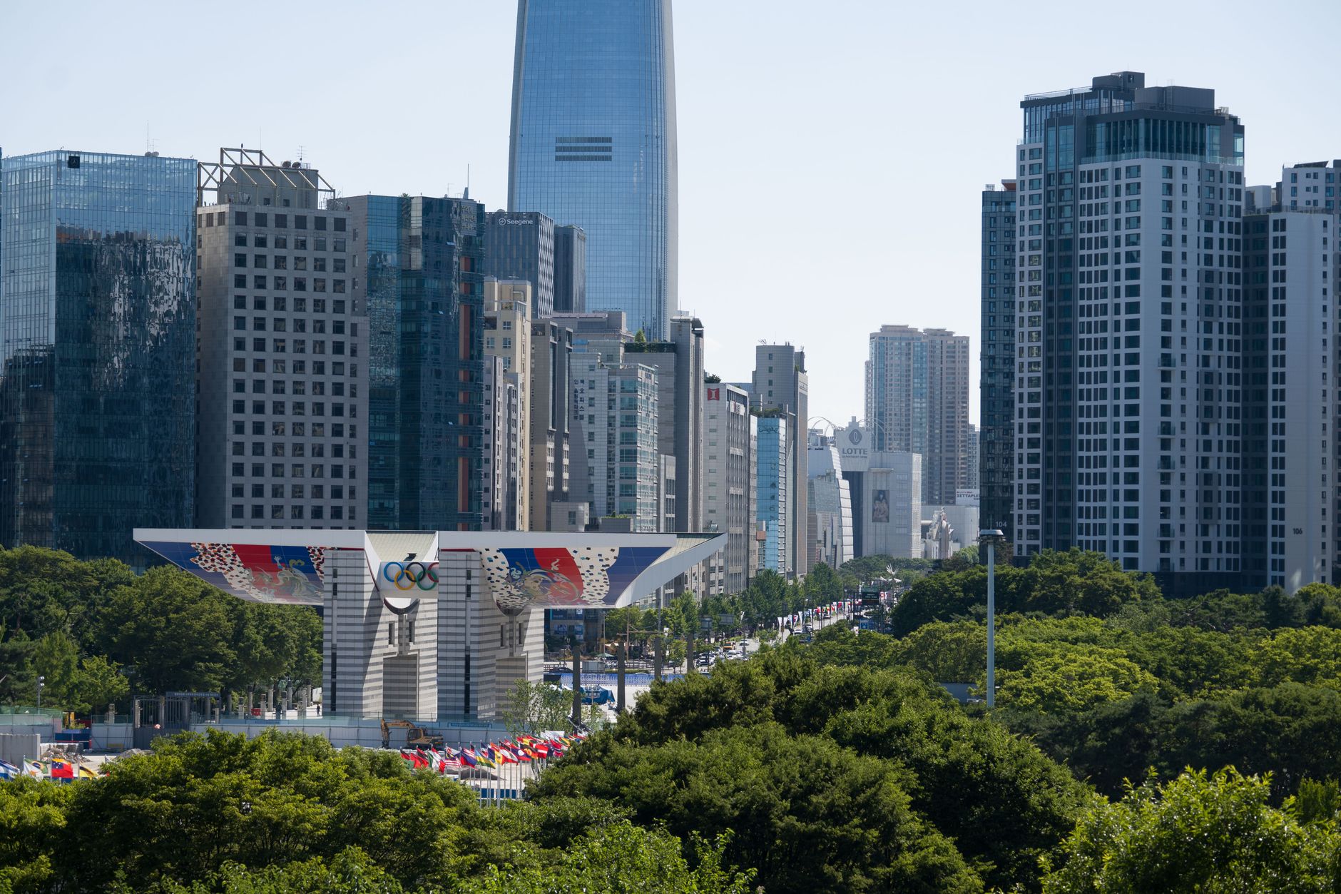 A view of Seoul's modern skyline, featuring the iconic Olympic Gateway, under a clear blue sky.