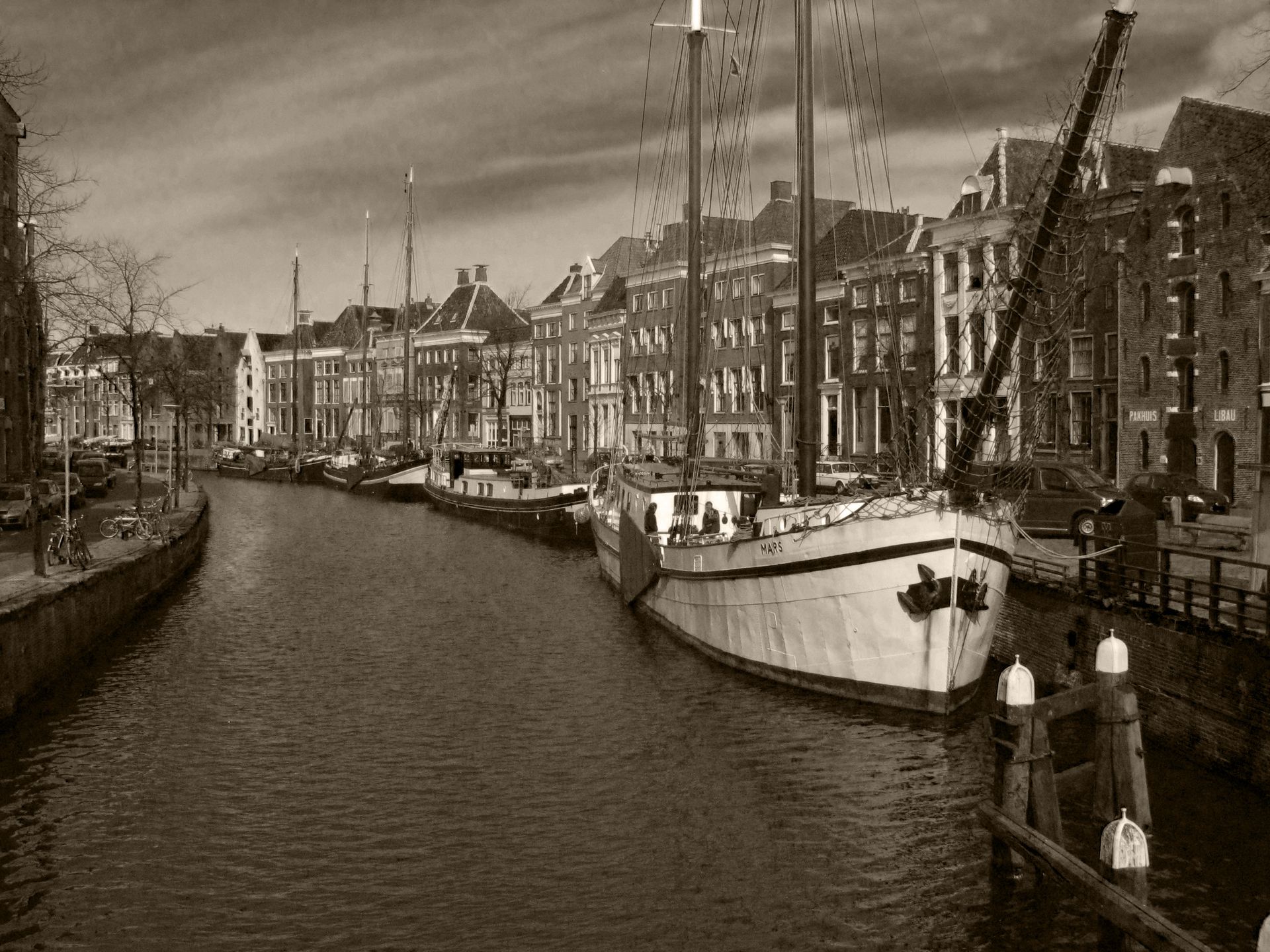 Una imagen en tono sepia de un antiguo barco comercial en un puerto