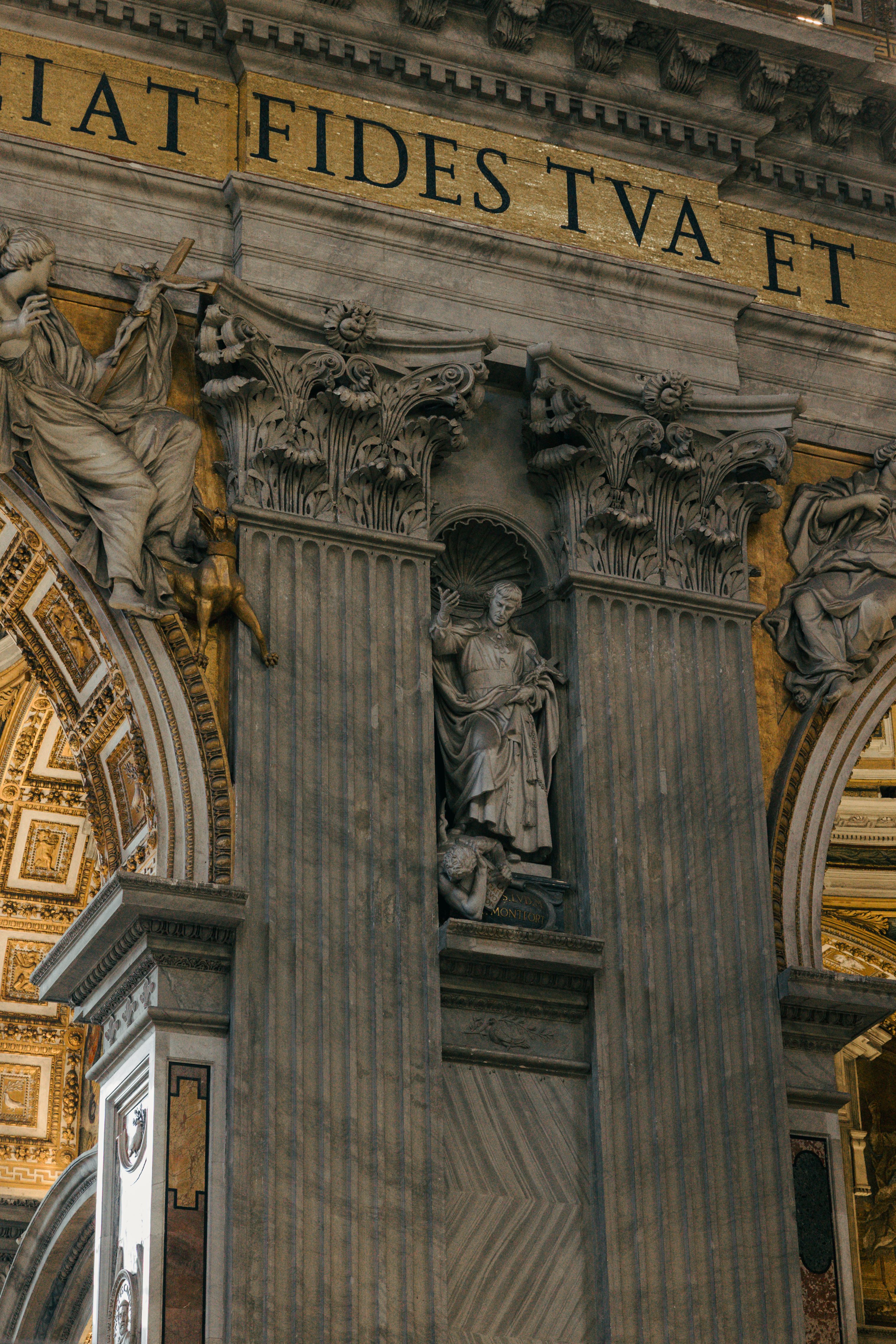 Intricate architectural details of St. Peter's Basilica with classical columns and statues.