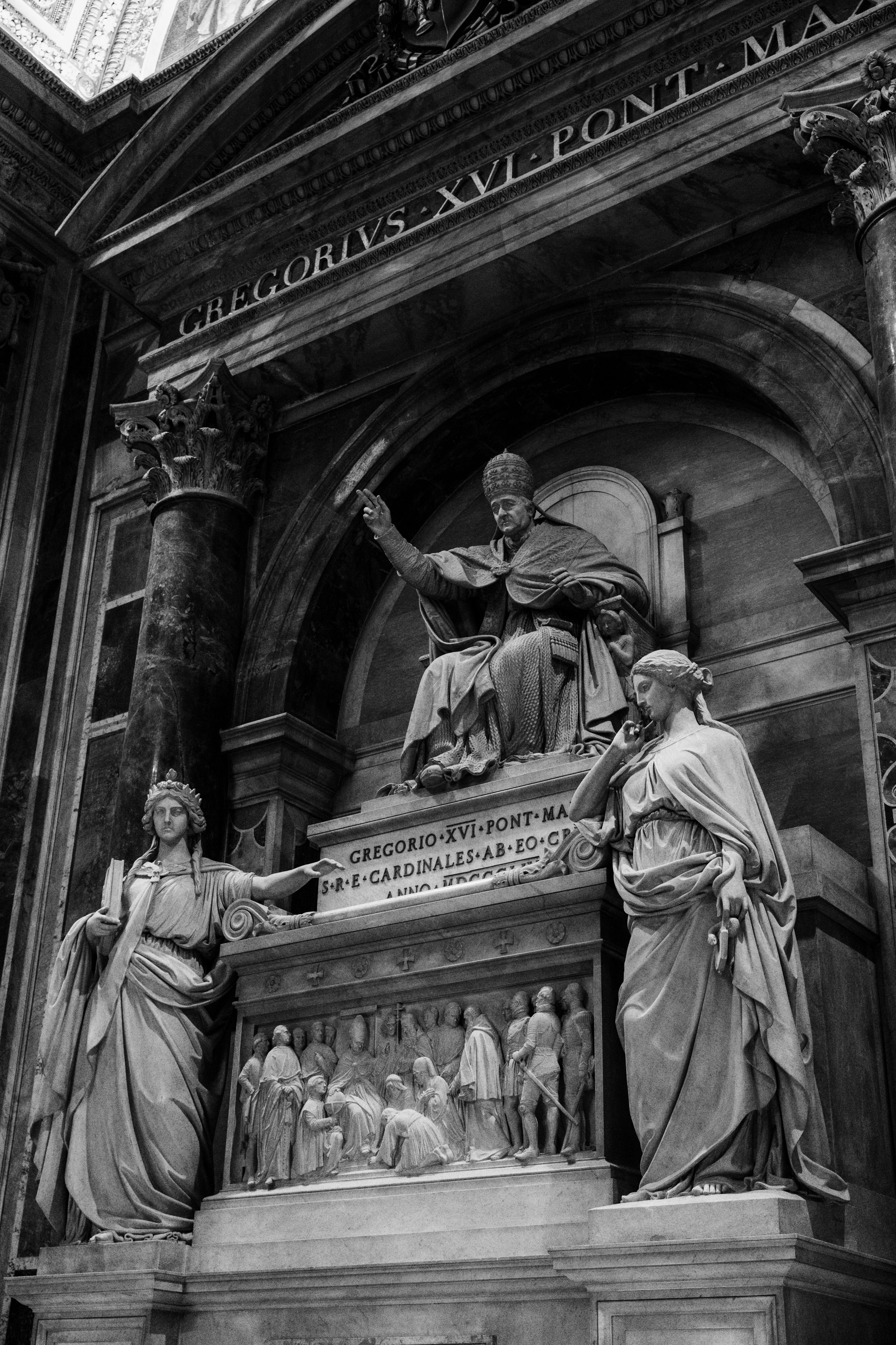 Black and white photo of sculptures inside St. Peter's Basilica, showcasing historic architecture.