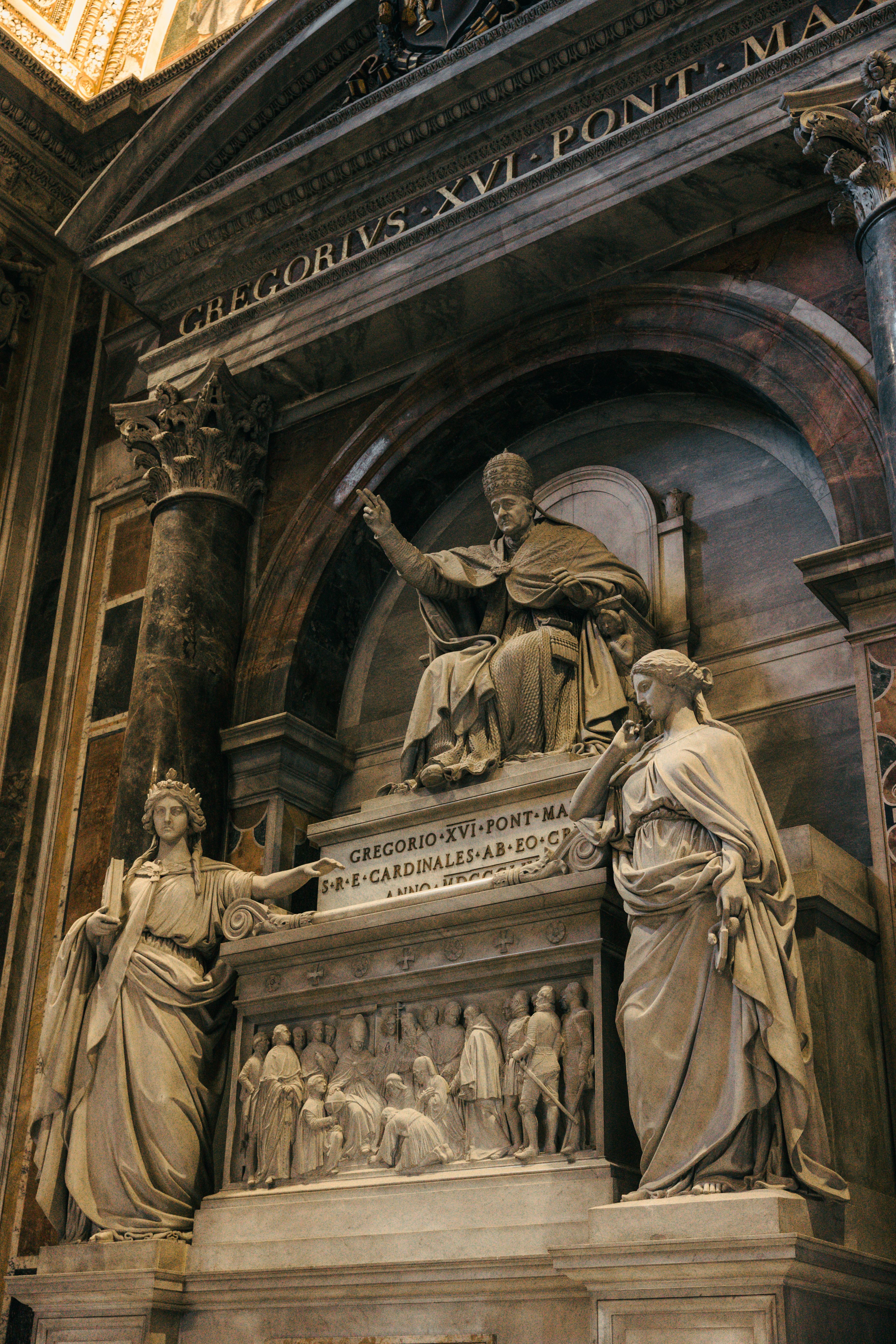 Marble sculptures inside St. Peter's Basilica portraying historical figures, showcasing intricate artistry.