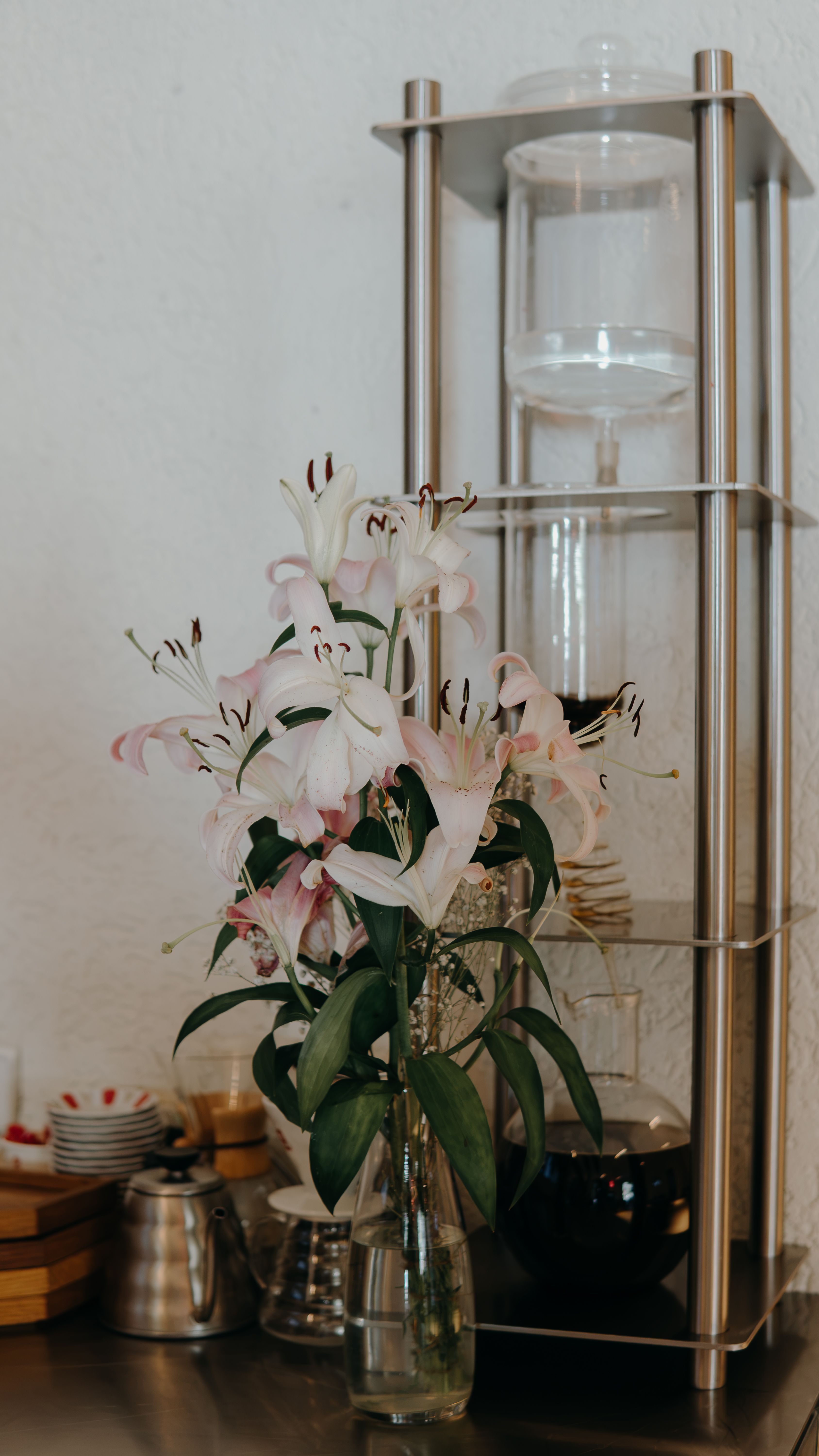 Small vase of fresh daisies placed on a coffee bar hutch shelf