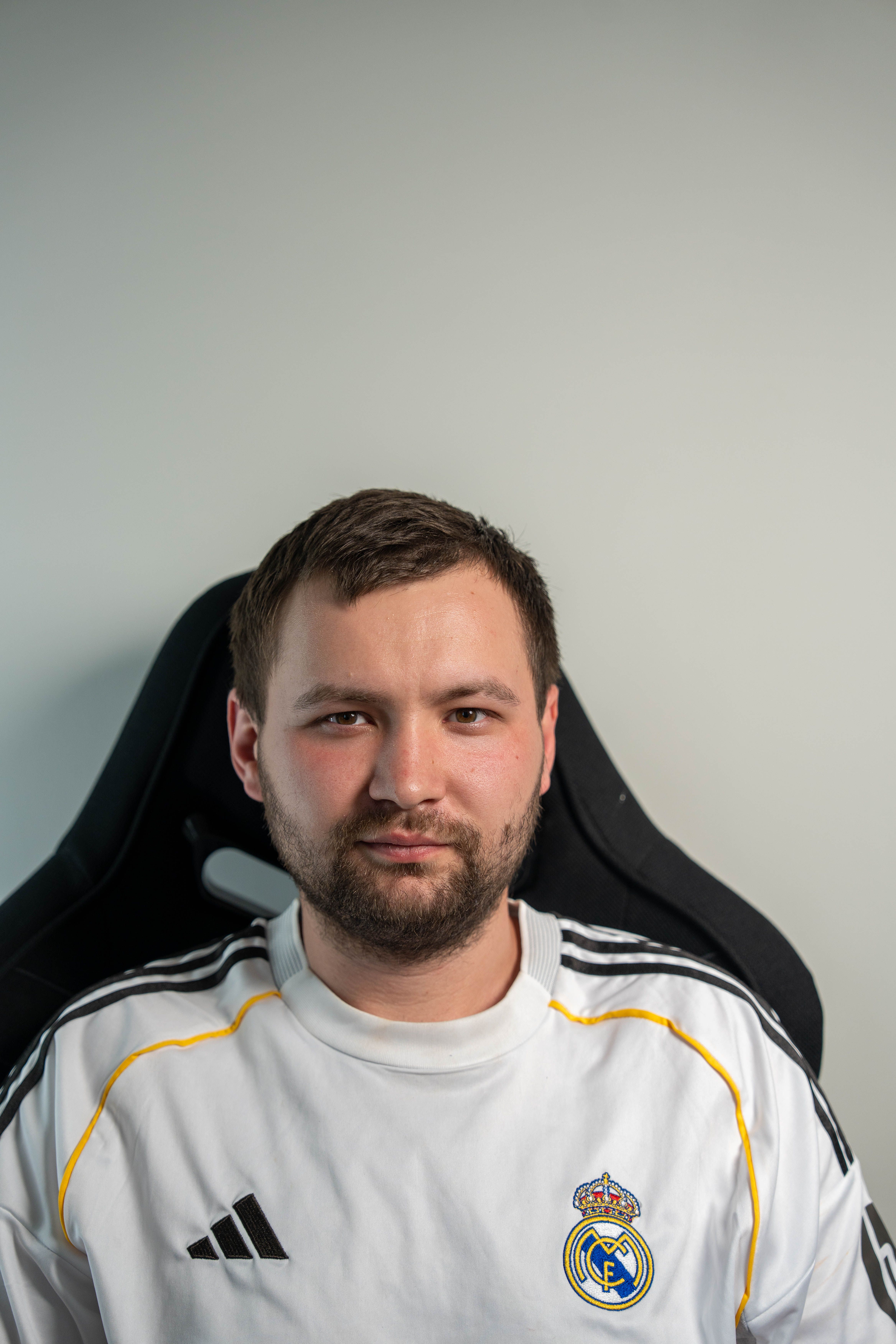 A man in a football jersey seated indoors, looking confidently at the camera.