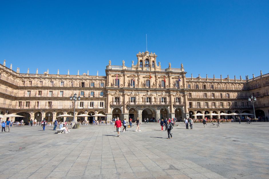 Una escena animada en la Plaza Mayor de Salamanca, España, con gente disfrutando del ambiente vibrante.