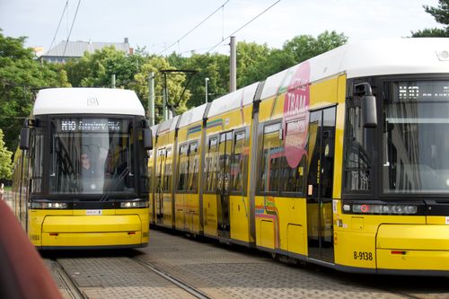 Free Yellow trams traversing Berlin's tracks amidst green surroundings, offering a glimpse into city transport. Stock Photo