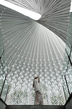 A person beneath a striking contemporary architectural ceiling in Chongqing, China.