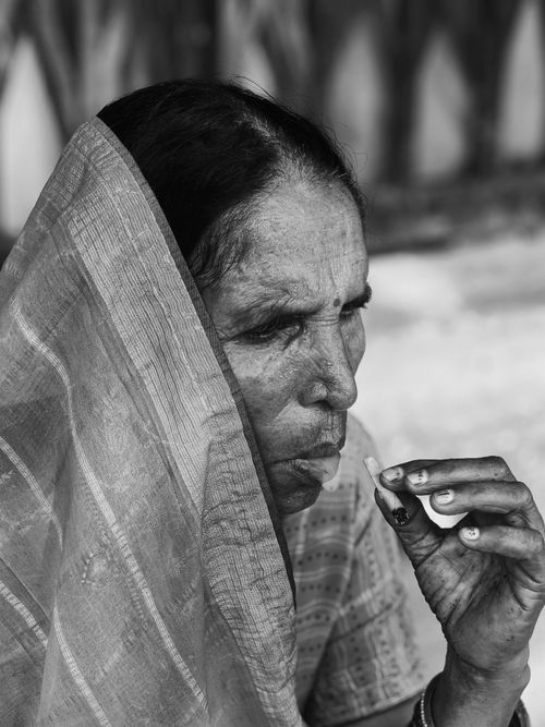 Free A senior woman enjoying a traditional snack in a tranquil outdoor setting. Stock Photo