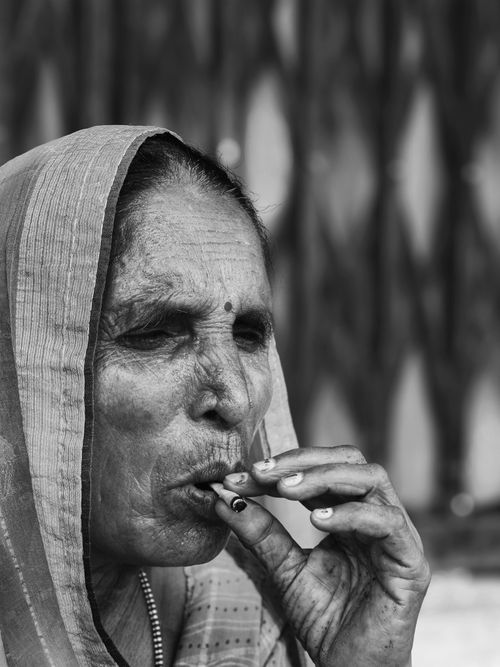 Free Black and white portrait of an elderly woman smoking, wearing traditional attire, capturing cultural nuances. Stock Photo