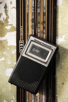 A classic National Panasonic transistor radio hanging against a weathered wall, evoking nostalgia.