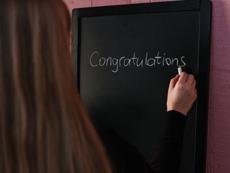 Woman in Black Long Sleeve Shirt Writing on the Chalkboard
