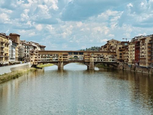 Free Beautiful view of the historic Ponte Vecchio bridge spanning across the Arno River in Florence, Italy. Stock Photo