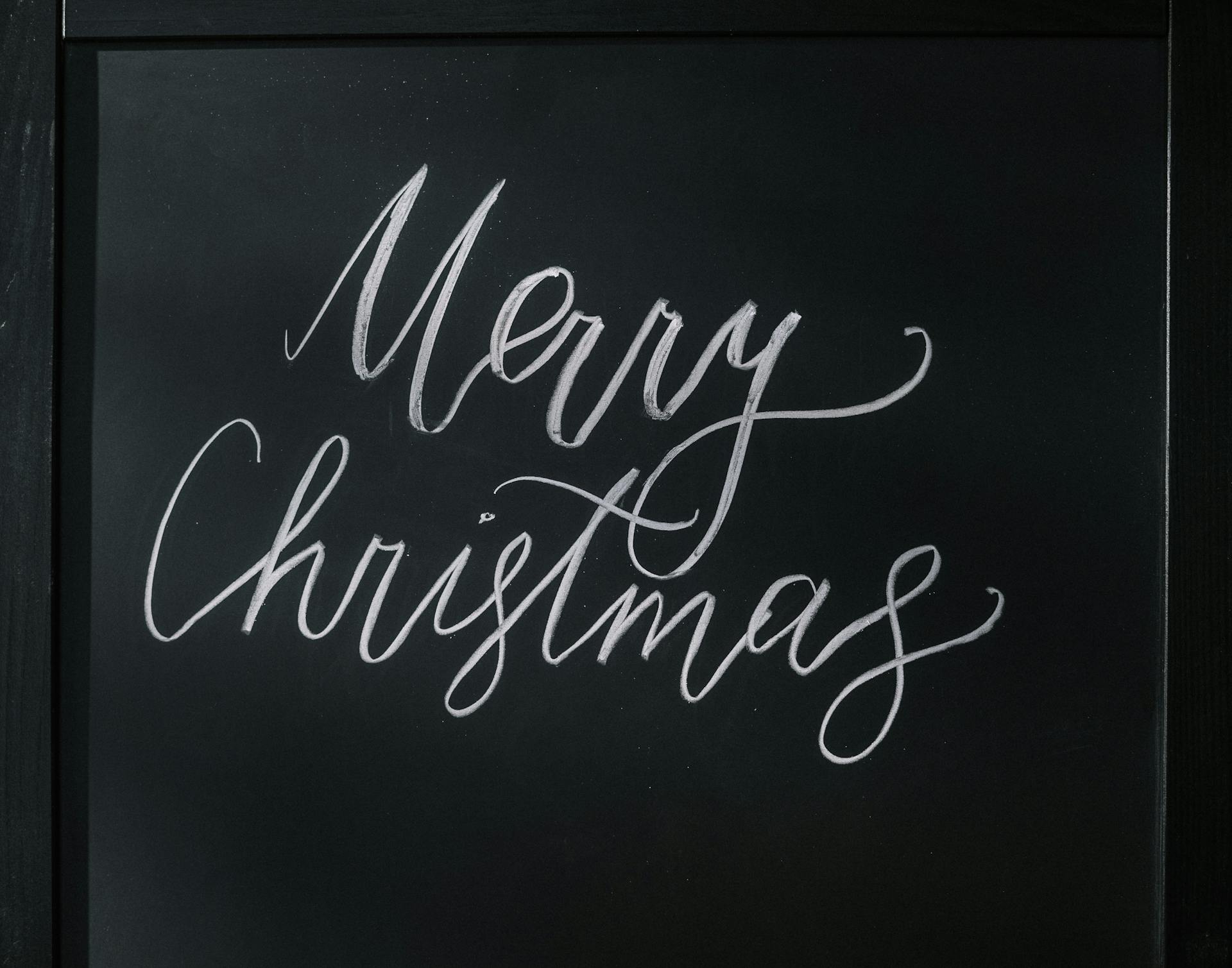 Handwritten 'Merry Christmas' on a stylish chalkboard, perfect for festive decoration.