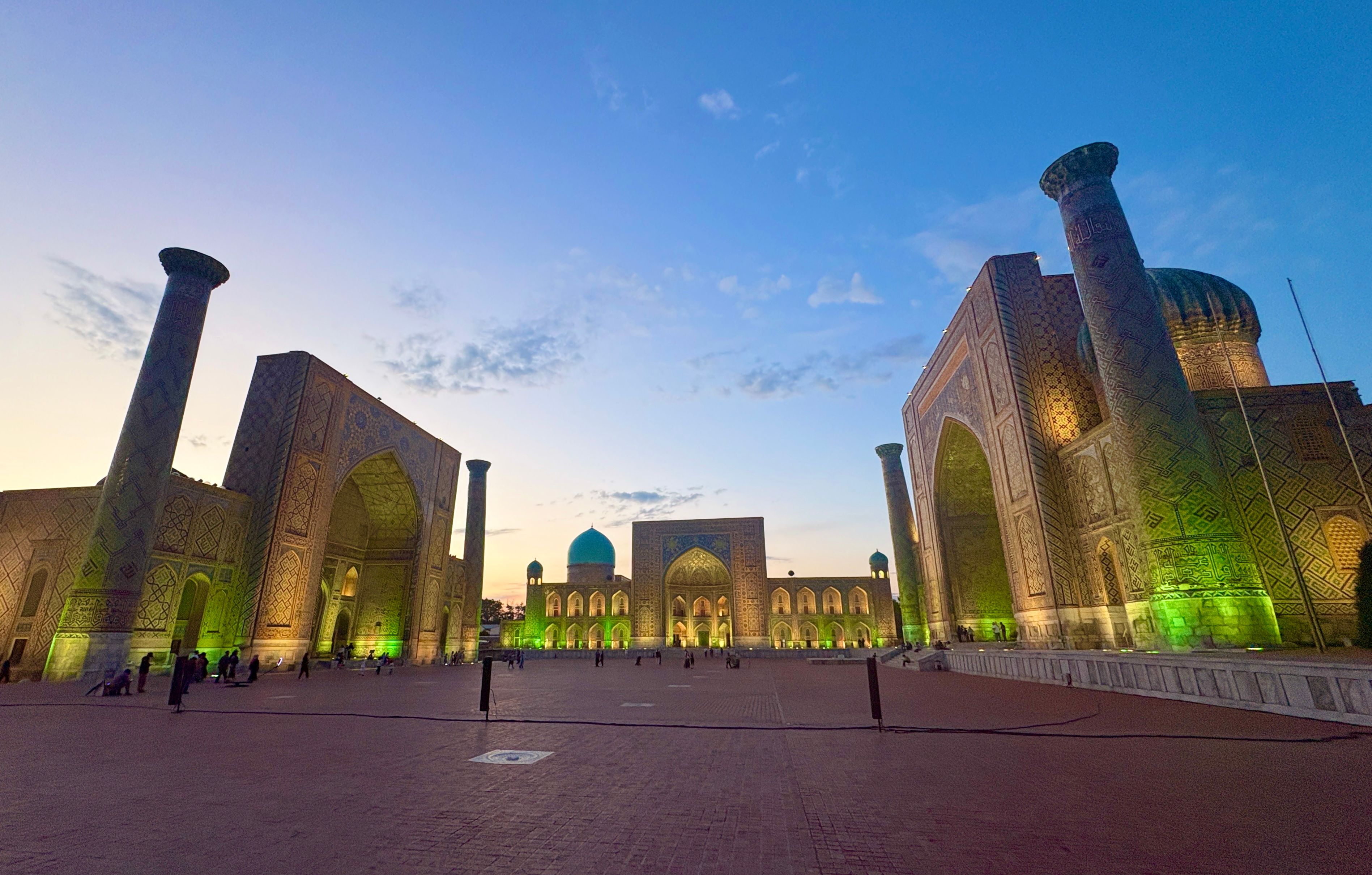 Stunning view of Registan Square in Samarkand, Uzbekistan at sunset, with illuminated architecture.