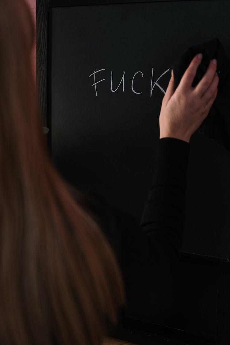 Woman In Black Long Sleeve Shirt Erasing The Chalkboard