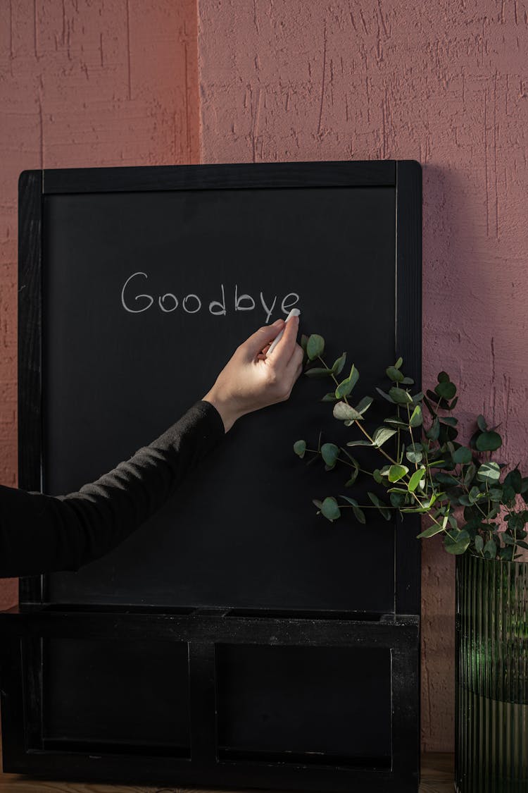 Person Writing On Black Board With Chalk