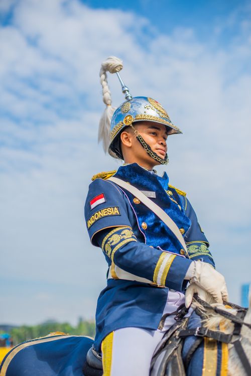 Free Indonesian soldier in ceremonial uniform riding a horse during a parade. Stock Photo