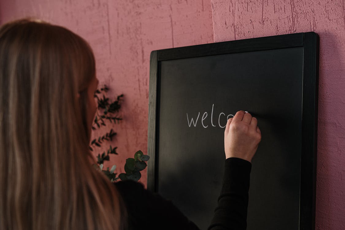 Free Woman in Black Long Sleeve Shirt Writing on the Chalkboard Stock Photo