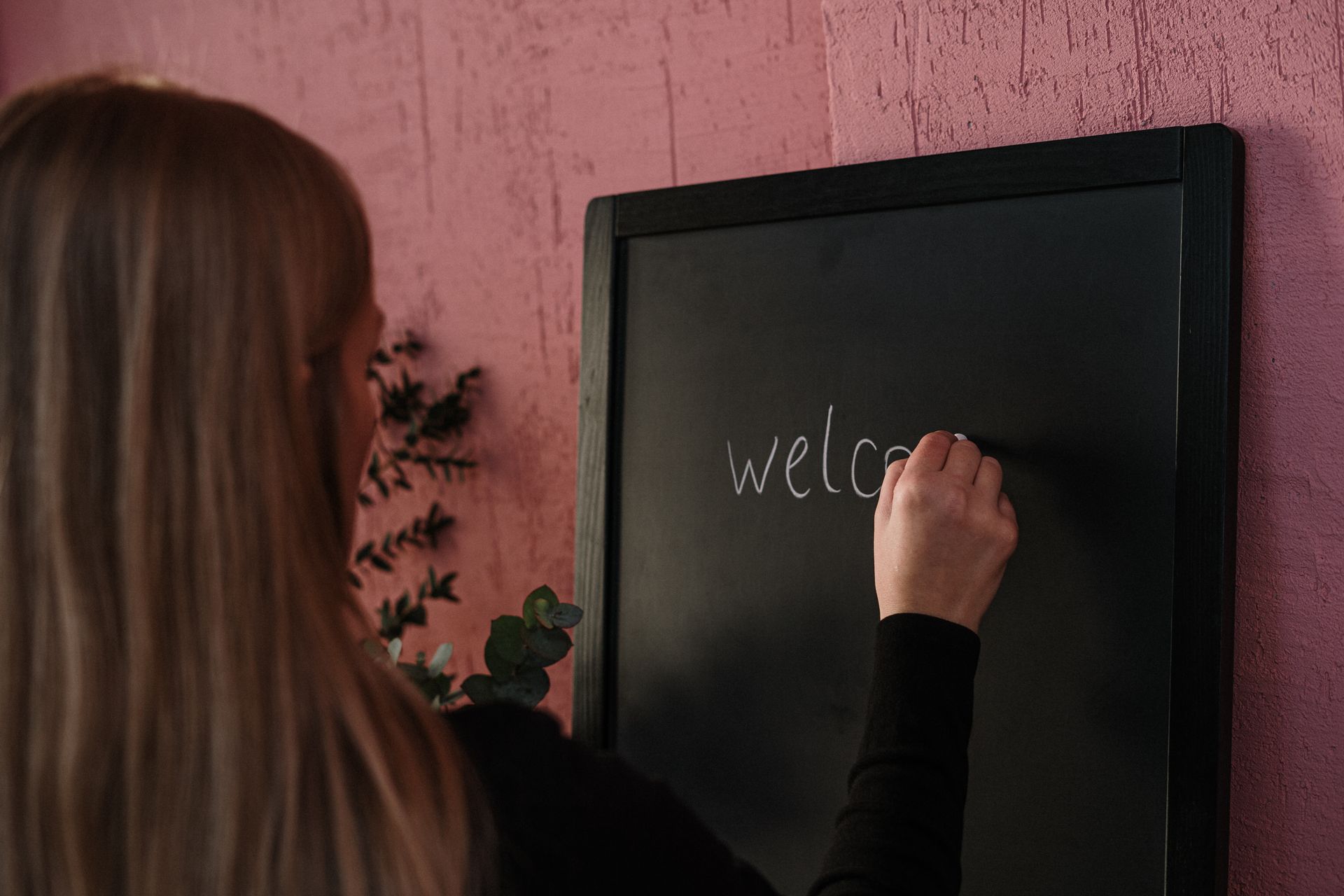 Woman in Black Long Sleeve Shirt Writing on the Chalkboard