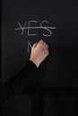 在黑板上手写，先划掉“是”，然后在下面写上“否”，以此说明决策