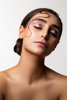 Close-up portrait of a woman with natural makeup and sleek hairstyle.