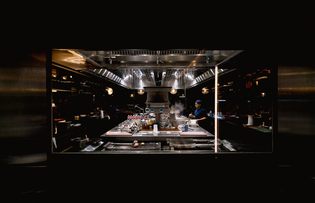 A cook alone on the late shift in an industrial kitchen at night — photo by Ayyeee Ayyeee on Pexels