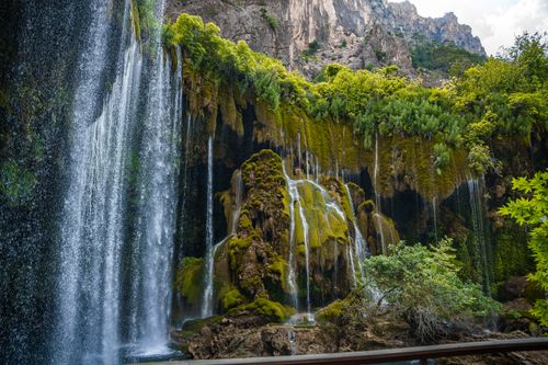 Free Lush greenery surrounds a powerful waterfall in the mountains of Mersin, Turkey. Stock Photo