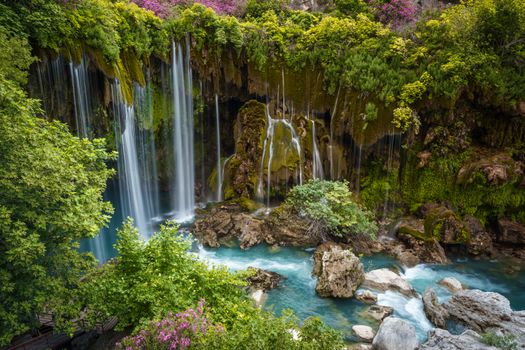 A powerful waterfall cascading in a lush, green landscape in Mersin, Türkiye.