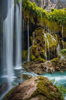 Serene waterfall cascading over green mossy rocks in Mersin, Türkiye.