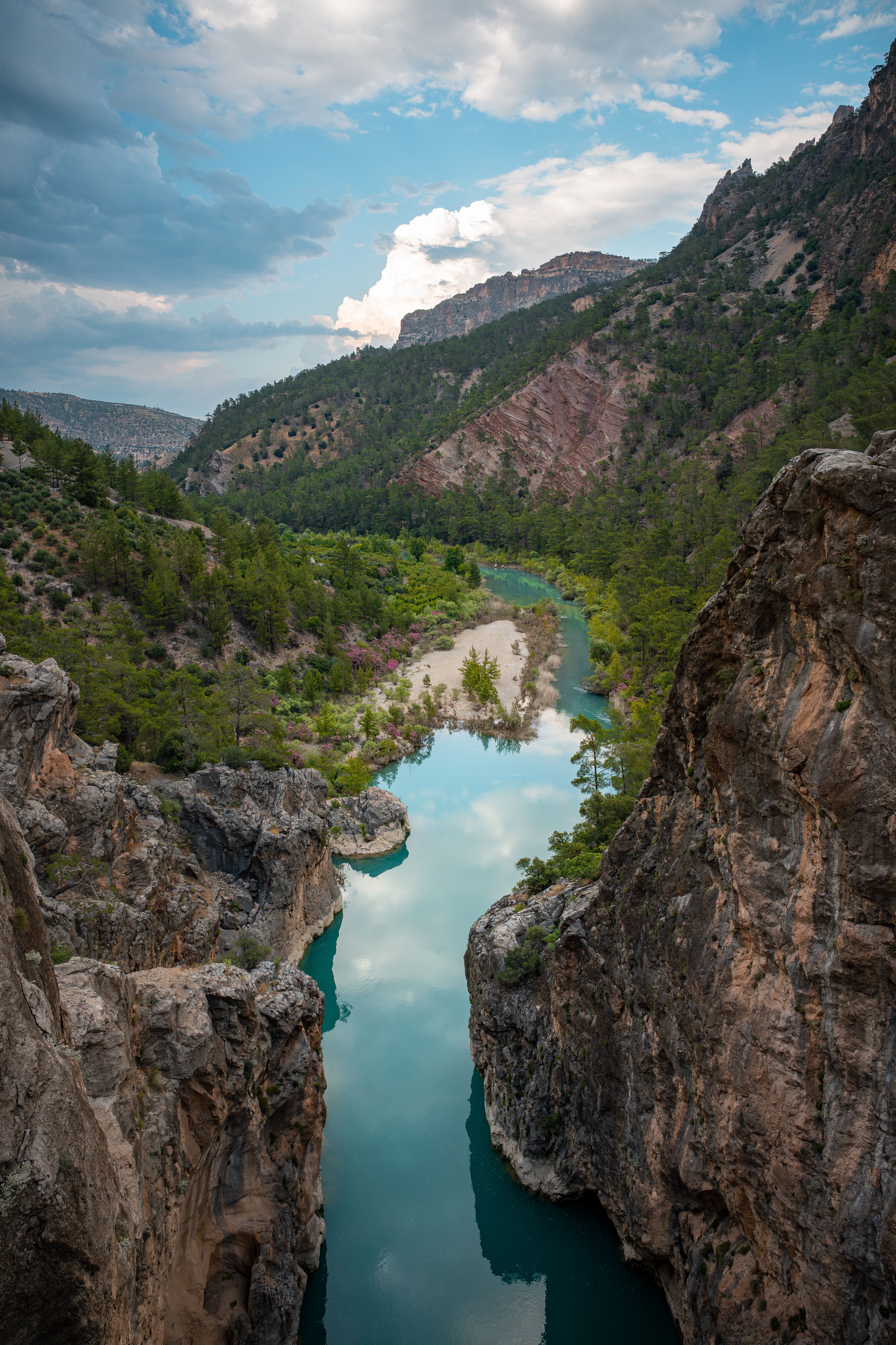 A tranquil river winding through a dramatic rocky canyon and lush greenery in Mersin, Türkiye.