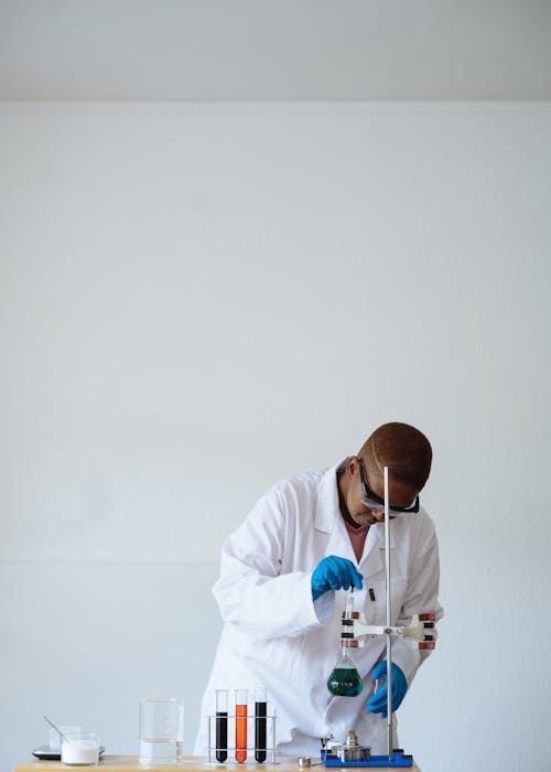 African American teen scientist in protective eyewear conducting chemical test in class