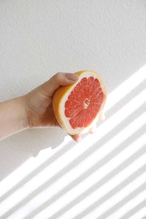 A Person Holding a Sliced Grapefruit