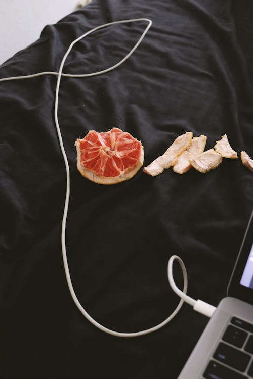 A Cord and an Eaten Grapefruit on a Black Cloth