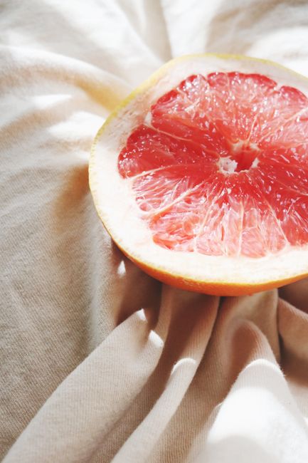 Fresh grapefruit half on a textured cloth, capturing vibrant colors and juicy details.