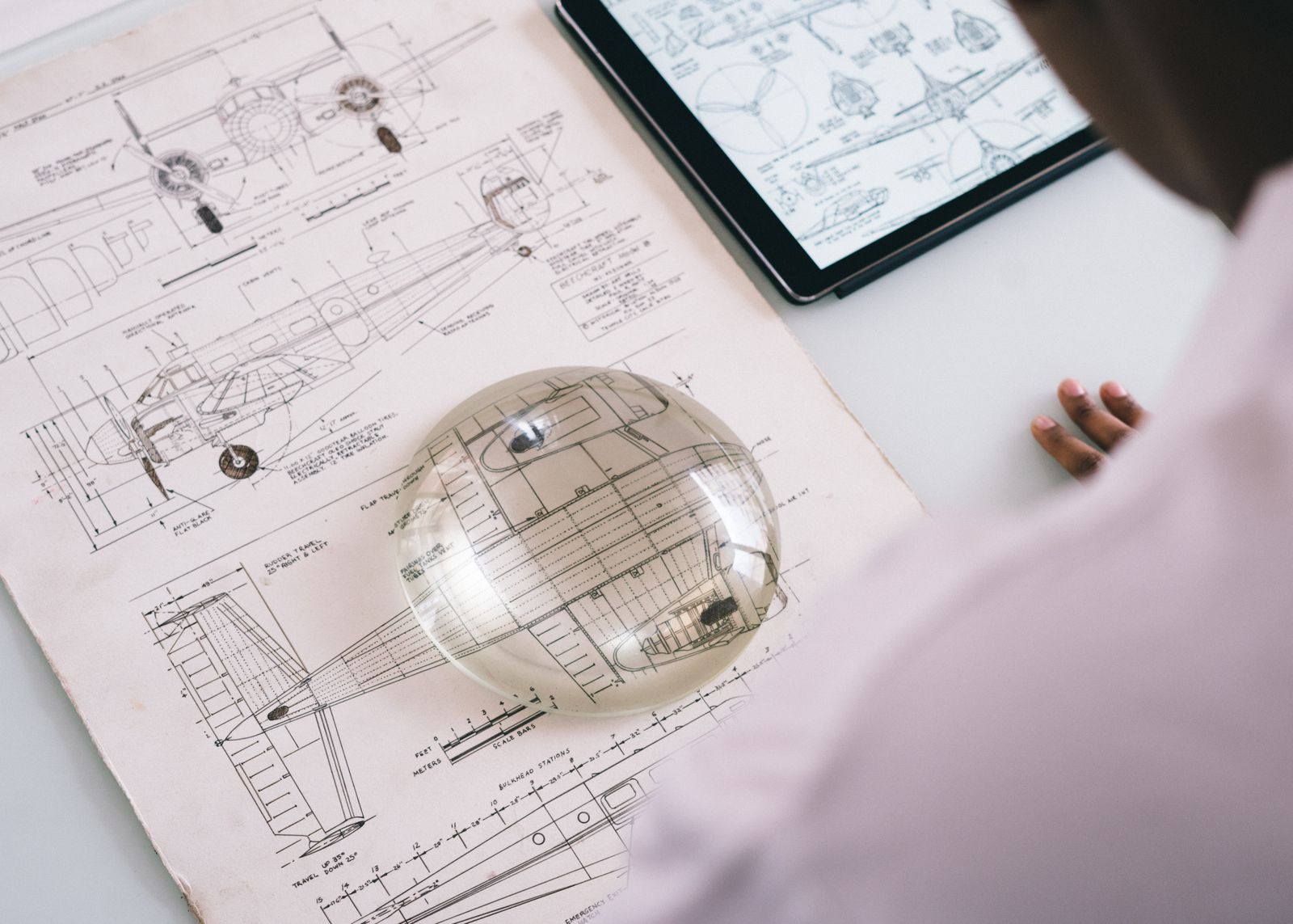 Studio del disegno tecnico di un aeromobile con tablet e lente