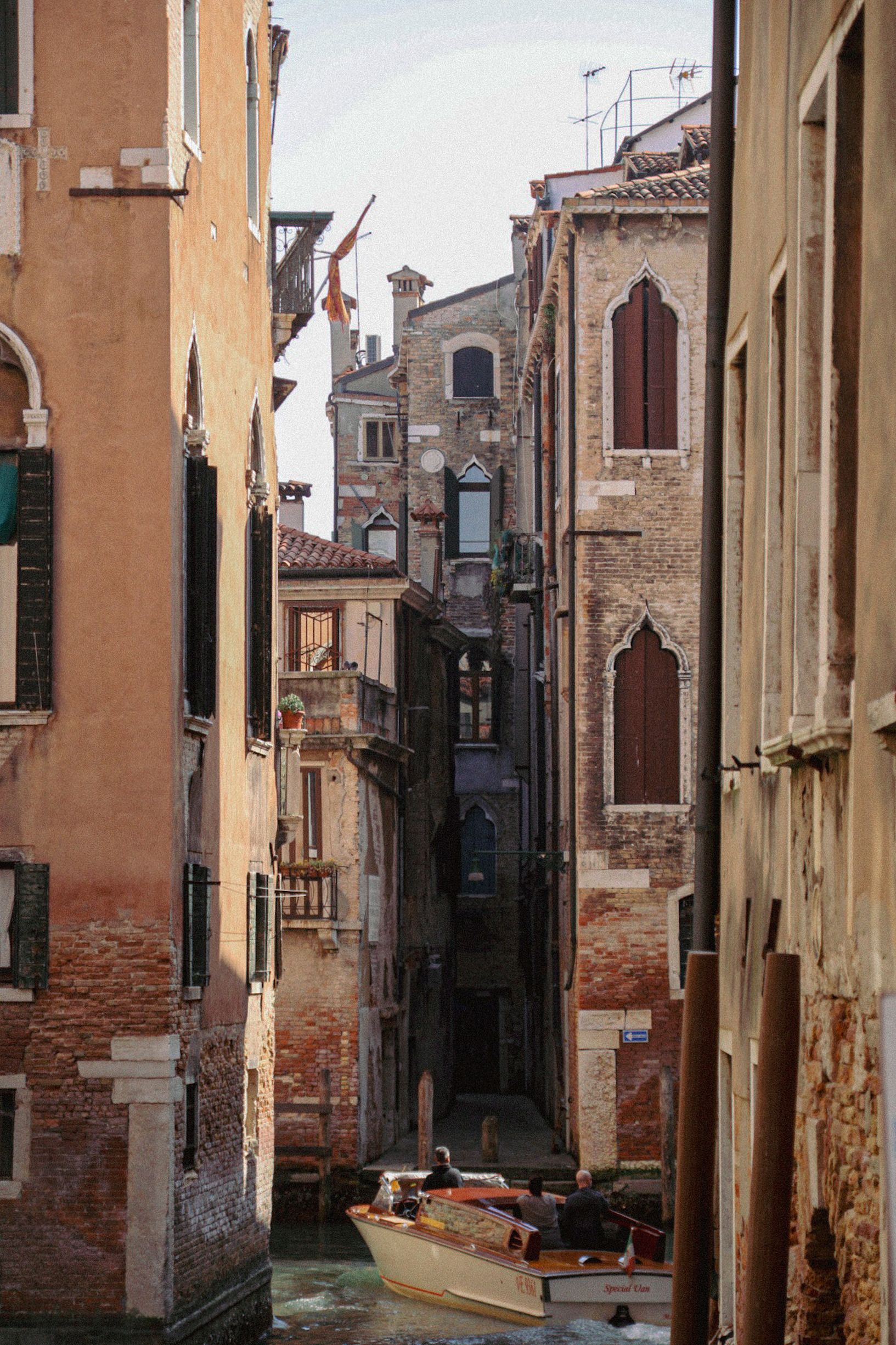 Charming canal with a boat amidst Venetian architecture in Venice, Italy.