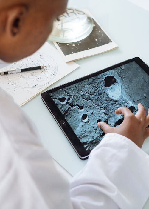 Astrofísico De Colheita Explorando A Superfície Da Lua Enquanto Usa Um Tablet Na Universidade